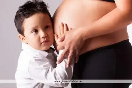 Scatto premaman con abito rosso in posa laterale