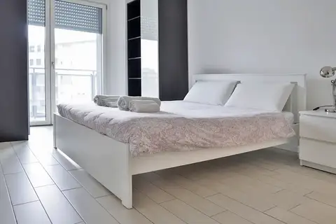 Camera da letto luminosa fotografata per Airbnb a Milano
