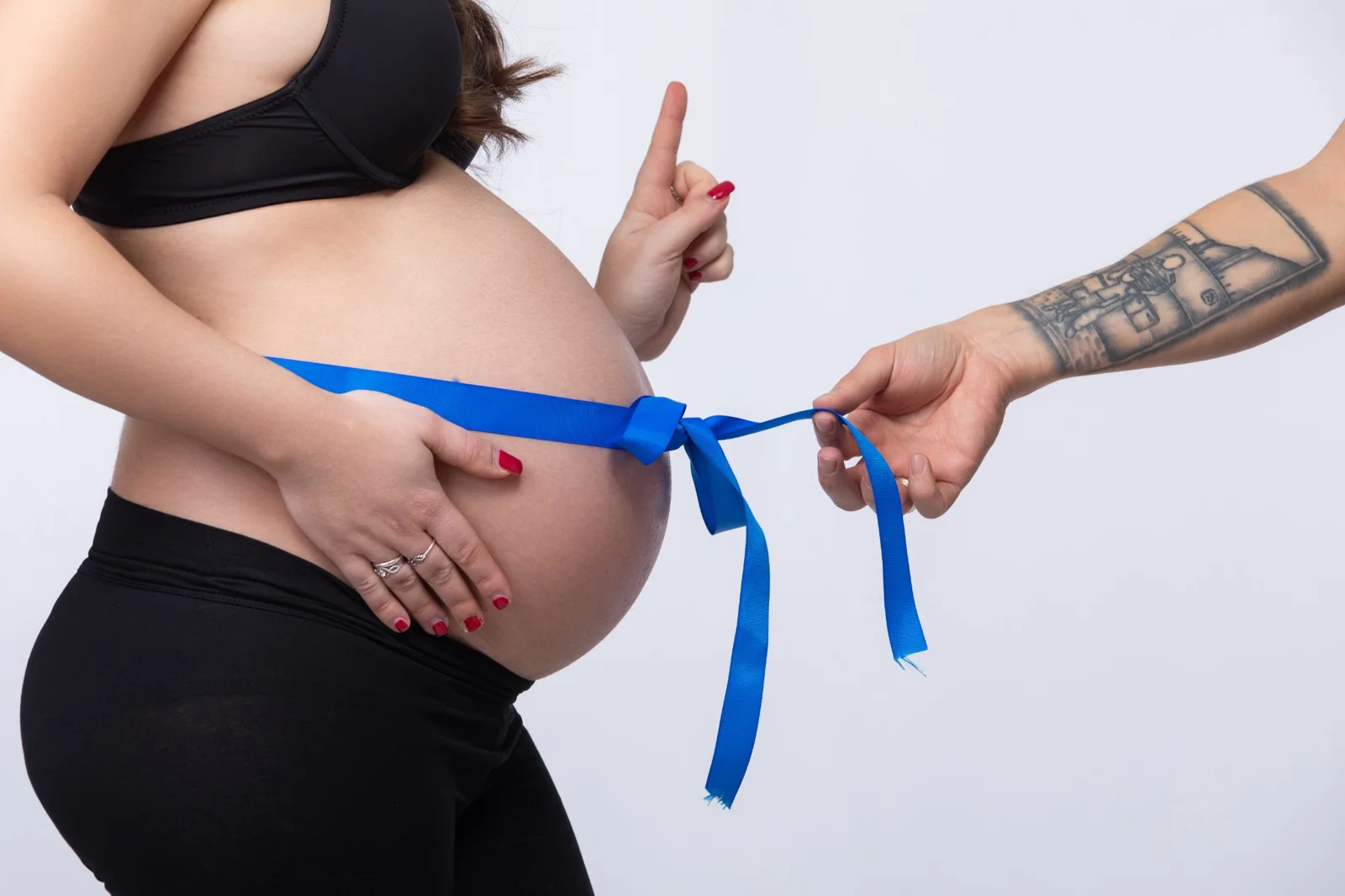 Fiocco blu legato al pancione per annunciare l'arrivo di un bimbo maschio