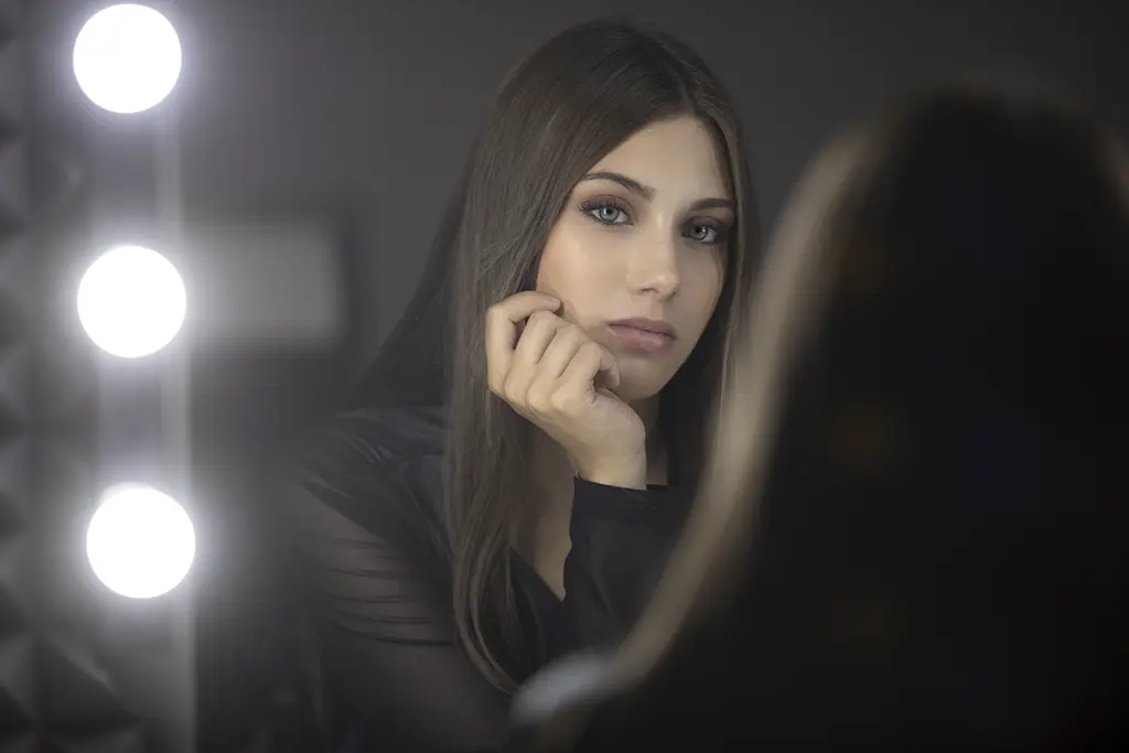 Ritratto femminile riflesso nello specchio con luci calde, idea regalo per servizio fotografico