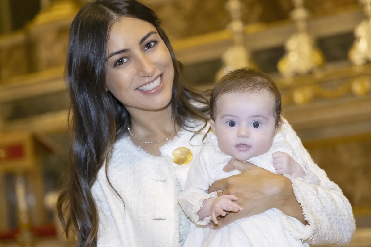 Mamma con figlia in braccio al battesimo, ritratto in chiesa Milano