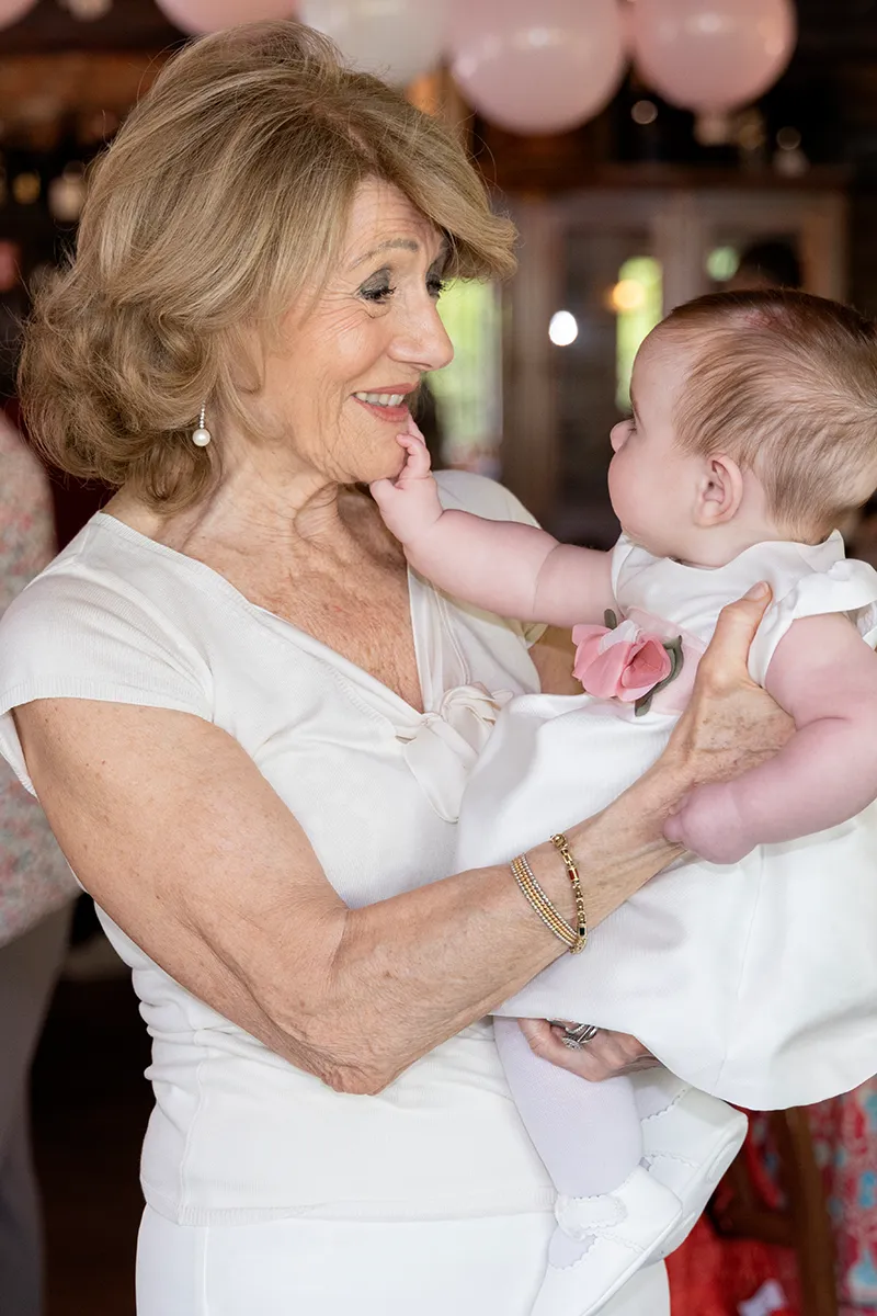 Festa di battesimo al ristorante a Milano, la nonna con la bambina in braccio tra i palloncini