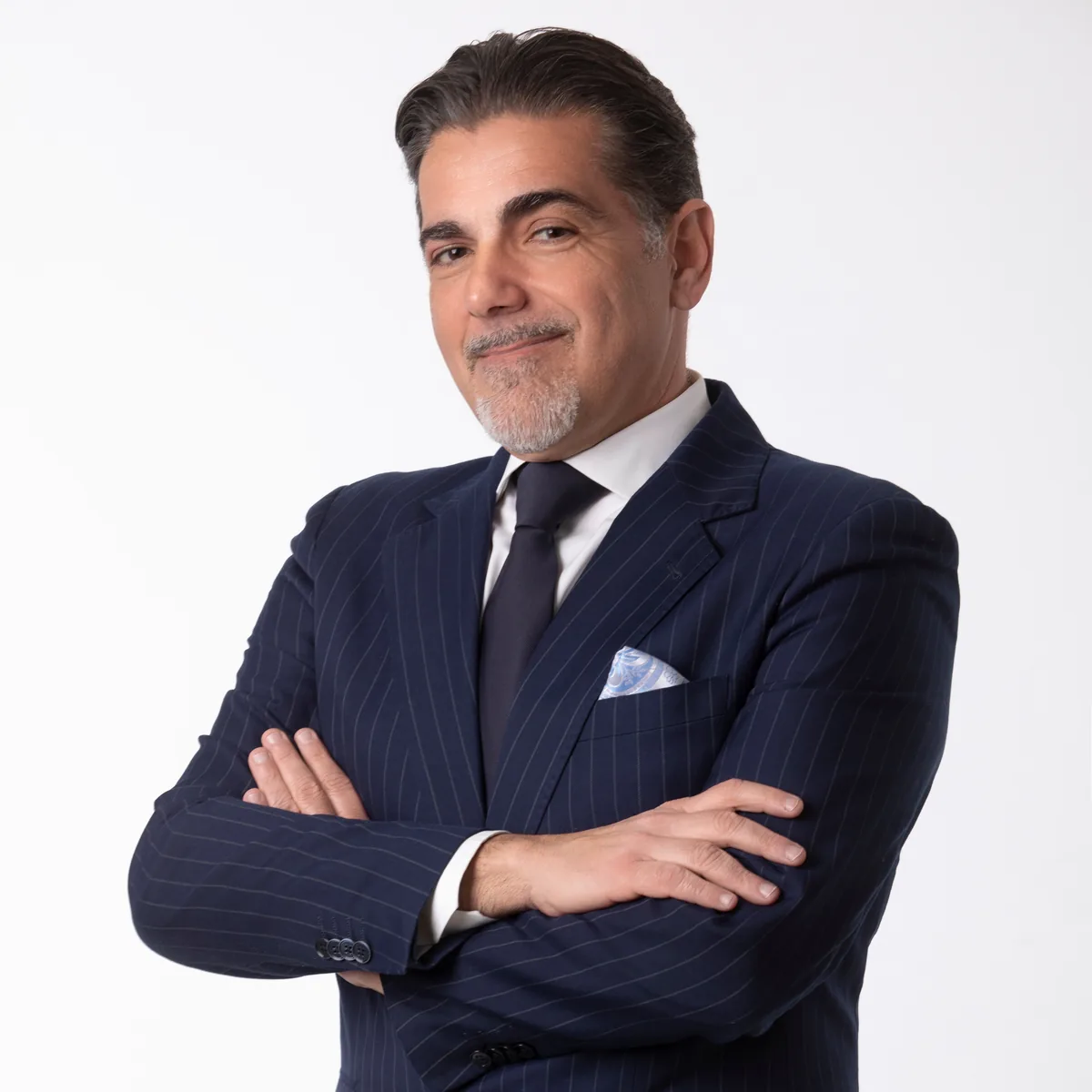 Foto profilo LinkedIn di un uomo brizzolato in abito scuro con pochette, studio a Milano