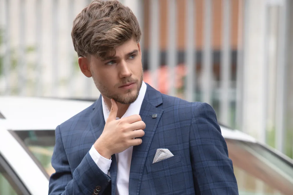 Ritratto uomo a Milano, giovane professionista con barba in giacca a quadri blu, scatto in esterna