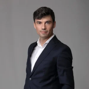Headshot LinkedIn di un uomo in abito blu su fondo grigio scuro, studio fotografico a Milano