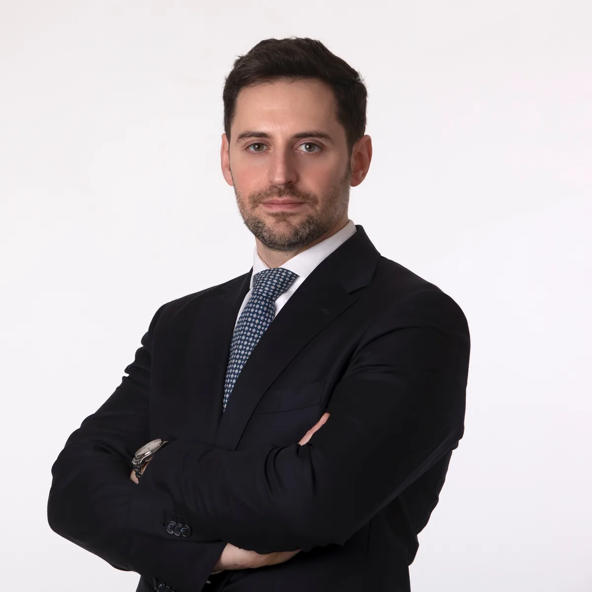 Ritratto professionale di un uomo in abito scuro con cravatta a pois, studio fotografico a Milano