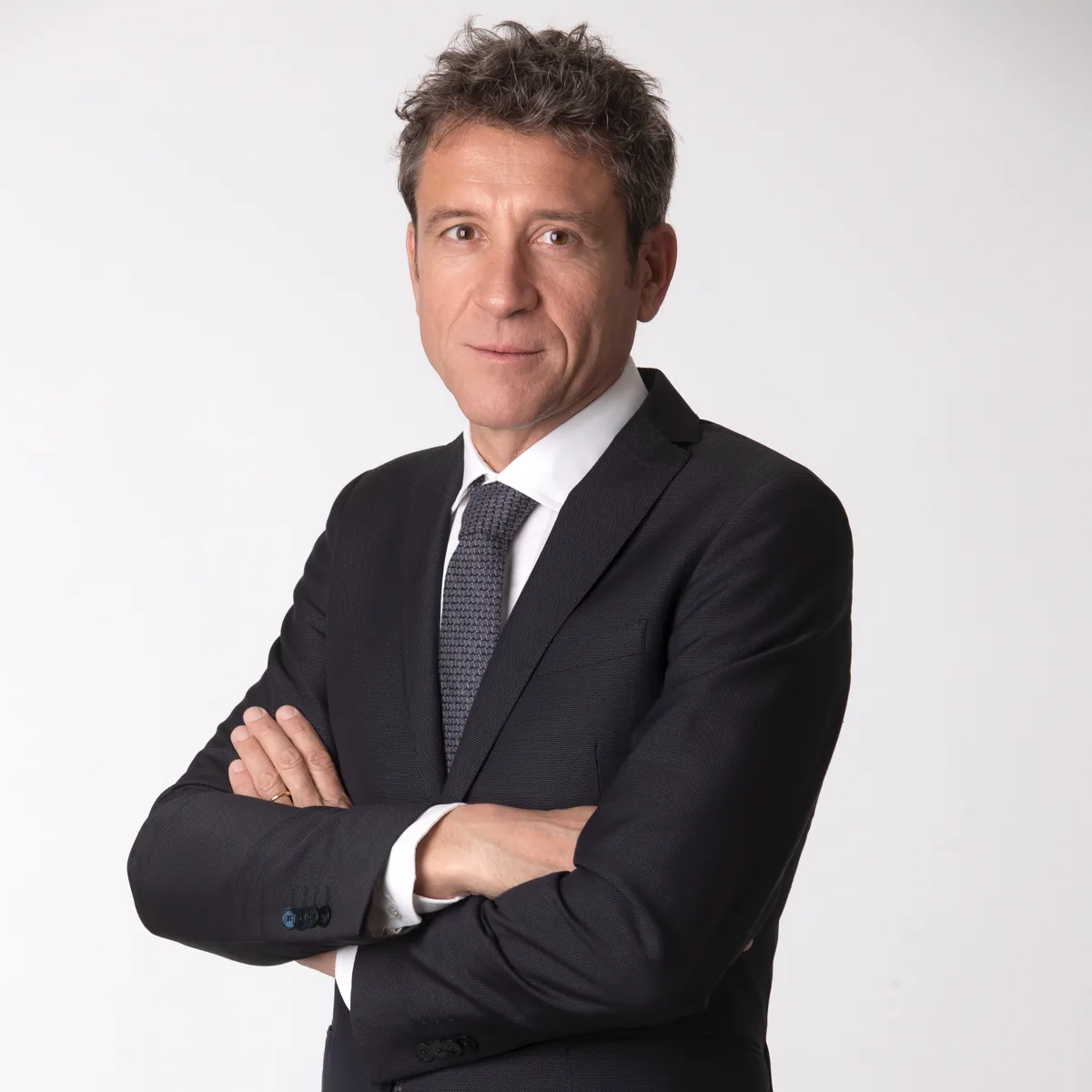 Ritratto in studio di un professionista senior in abito scuro e cravatta, foto LinkedIn a Milano