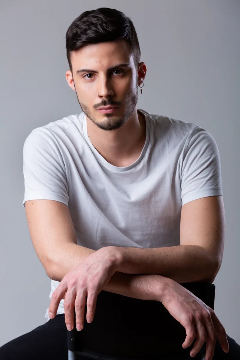 Giovane attore in t-shirt bianca seduto